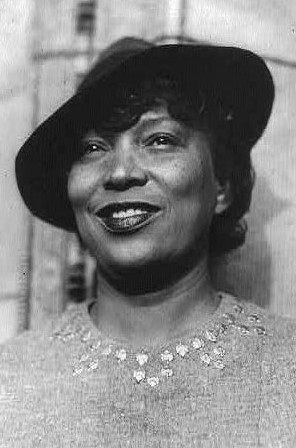 Zora Neale Hurston smiling and wearing a hat at an angle.