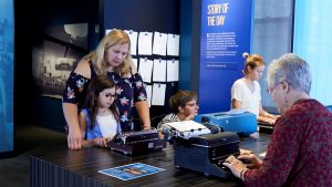 Adults and children interact with typewriters at the American Writers Museum