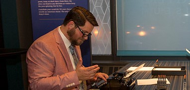 A man using a typewriter at the American Writers Museum