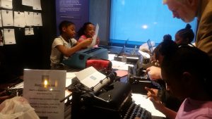 Students on a field trip at the American Writers Museum in Chicago learn how to write on typewriters