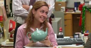 Pam from The Office holds her teapot gift from Jim