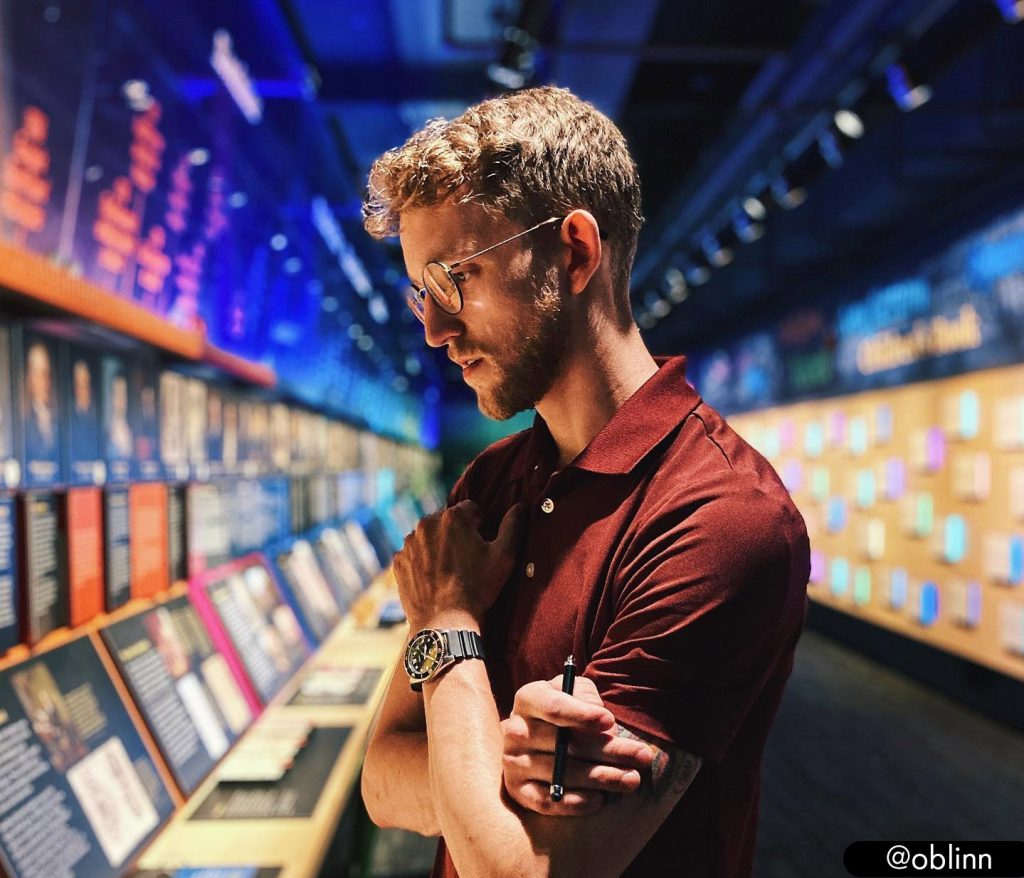 A man with crossed arms looking at an exhibit at the American Writers Museum in Chicago. Photo by @oblinn