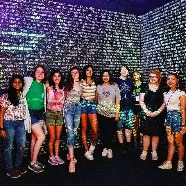 A group of students posing under the Word Waterfall installation at the American Writers Museum in Chicago
