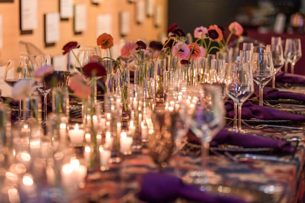 A pink and purple table setting with wine glasses and flowers for a private rental event at the American Writers Museum in Chicago