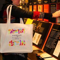 A woman in the American Writers Museum with an American Writers Festival tote bag over her shoulder.