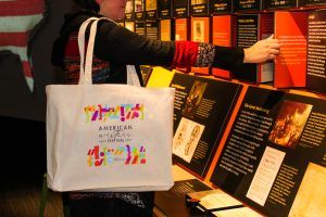 A woman in the American Writers Museum with an American Writers Festival tote bag over her shoulder.